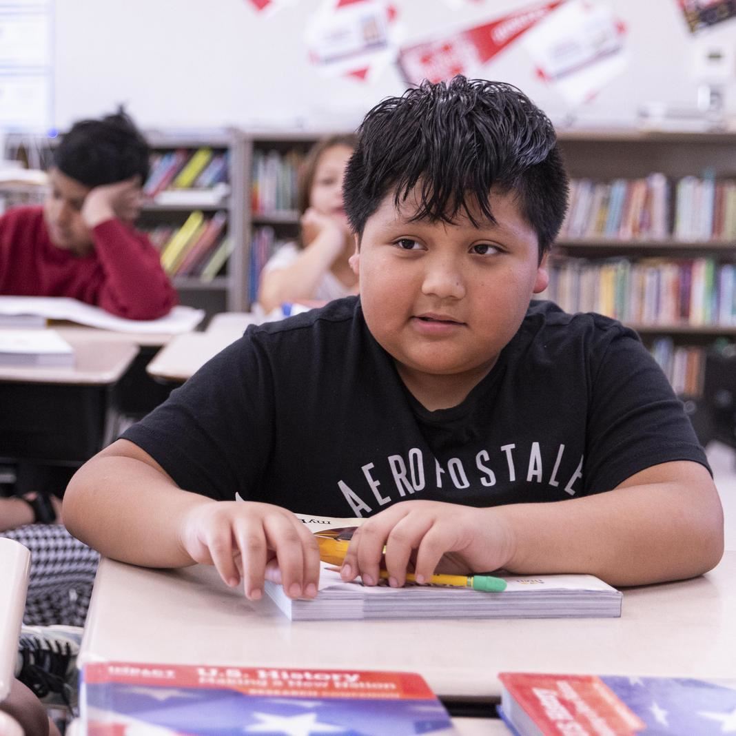  A student looks up from a task at his desk